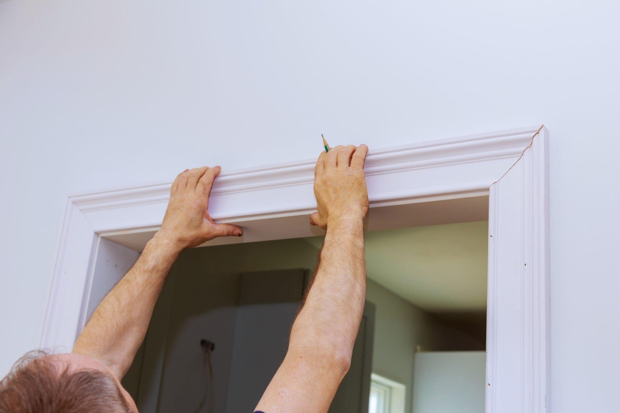 Someone installing trim above a door