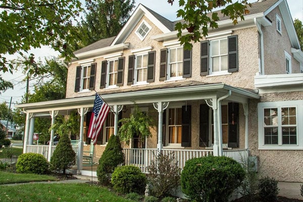 Black Louver Wood Shutters on home with an American flag