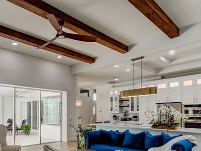 Light Brown ceiling beams with a fan attached in a medeterain styled home.